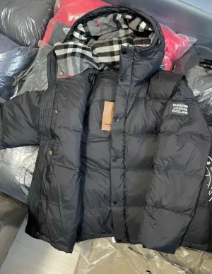 Svart pufferjacka från Burberry ingår burrbery tröja  - Säljer en svart pufferjacka från Burberry London England med klassisk rutmönstrad huva. Jackan har hög krage, knappstängning och en cool Burberry-logga på ärmen. Perfekt för kalla dagar och riktigt snygg till streetwear-stilen.  Det finns i storlek S och M. Hämtas i Karlstad annars fraktar  jag via   Plick 🚚📦