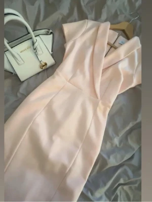 Ljusrosa klänning - Jätte snygg ljusrosa klänning som kommit till användning en gång. Den går till under knäna och är tight 