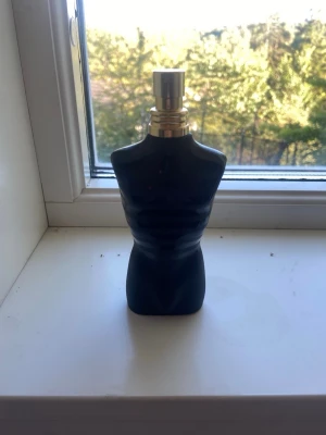 Svart parfymflaska i form av torso - Säljer en svart parfymflaska formad som en manlig torso med guldfärgad spraydel. Flaskan har en stilren och unik design som sticker ut på hyllan. Perfekt för dig som gillar snygga detaljer i badrummet eller på sminkbordet. 75 ml ca 30-40 kvar 