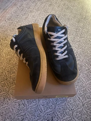 Paul Smith marinblå Gats - Snygga marinblå Gats från Paul Smith med ovandel i mocka och läder, vita skosnören och klassisk gummisula i beige. Diskret PS-logga på plösen och hälen och sidan av skon. Perfekta för dig som gillar Gats.