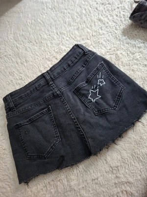 Svart jeanskjol med broderade stjärnor - En kjol klippet från shorts. Gjorde stjärnorna själv men blev lite bajs. PRISET KAN DISKUTERAS!! 😳😙