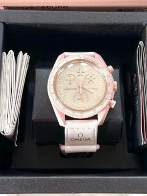 Omega Speedmaster MoonSwatch rosa/vit - Säljer en Omega Speedmaster MoonSwatch med rosa boett och vit urtavla. Klockan har kronograf, tachymeter och vit textilrem med Omega-logga. Snygg och modern design som sticker ut på handleden.