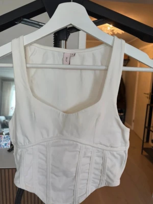 Korsett topp  - Vit korsett topp från Nelly som skapar en fin figur, storlek S. Aldrig använd. 