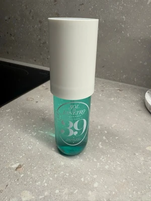 Sol de Janeiro 39 parfym mist - Fräsch parfym mist från Sol de Janeiro i en snygg turkos glasflaska med stor vit plastkork. Flaskan har en modern och stilren design med tydlig märkning och siffran 39 på framsidan. Perfekt att ha med i väskan för en uppfriskande doftboost.knappt använd