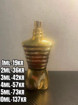 Gul parfymflaska i form av torso - Snygg parfymflaska i guld med en unik design som liknar en manlig torso. Flaskan har horisontella ränder och en metallisk finish som ger ett lyxigt intryck. Perfekt för dig som vill ha något som sticker ut på parfymhyllan.
