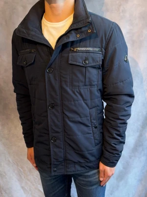 Marinblå J-Lindeberg Bailey Fieldjacket- Stl L - Riktigt snygg Vår/Höst Bailey Fieldjacket från J-Lindeberg i färgen marinblå! | Mycket bra skick: 9/10, inga defekter | Stl: M, modellen är 178cm och väger 78kg, passar bra mellan 178-190cm 🙌  | Hör av dig vid frågor // Galgen 🫡