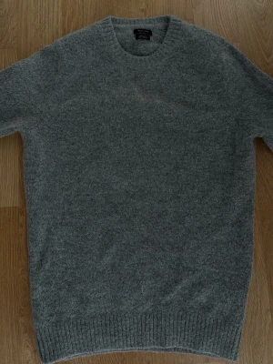 Grå stickad tröja i ullmix - Riktigt snygg tröja från Massimo dutti som passar perfekt nu till hösten/vintern. Otroligt najs passform och passar både dig som vill klä upp eller bara att ha hemma 