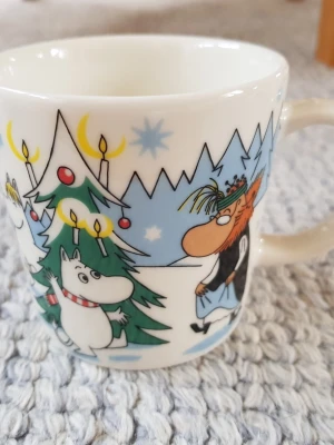 Muminmugg Under granen Mumin  - Felfri oanvänd mugg (utan etikett). Säljer fler Muminmuggar så kika gärna på mina övriga annonser också. Packar mycket noggrant. 