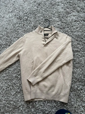 Beige stickad half-zip från Massimo dutti - Snygg beige stickad tröja från det italienska exklusiva märket Massimo Dutti! Tröjan är i extremt bra skick och har väldigt stil rena detalijer!