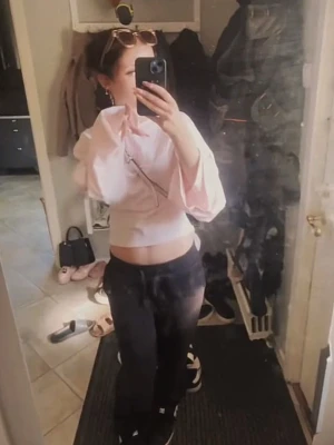 Ljusrosa croppad långärmad topp - Säljer en ljusrosa croppad topp med vida, långa ärmar. Toppen har en lös passform och är perfekt för dig som gillar en avslappnad men ändå trendig stil. Materialet känns mjukt och lätt, vilket gör den skön att bära.
