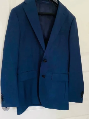 Blå kostym i nyskick - Snygg kostym i slim fit med matchande kavaj och byxor från Volt. Använd vid ett tillfälle av sonen förra sommaren så i nyskick! 😊