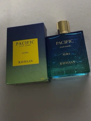 Pacific Aura av Rayhaan - 🌊 RAYHAAN PACIFIC AURA 🌊  En riktigt fräsch och clean doft som passar perfekt till sommaren ☀️🌴 ✨ Frisk • Söt • Tropisk • Lyxig vibe  Perfekt för dig som gillar dofter som känns nyduschade, fräscha och samtidigt lite söta 🤍  📦 Fint skick 💯 Äkta parfym 📩 Skriv gärna om du är intresserad eller har frågor!  🔥 En riktig sommardoft – först till kvarn!