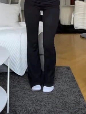 Svarta yoga pants  - Säljer ett par svarta yoga pants i storlek 158-164 från Gina Tricot. De är stretchiga och sitter tight över låren men släpper ut nedtill. Perfekta till en avslappnad och trendig look. Materialet känns mjukt och följsamt.
