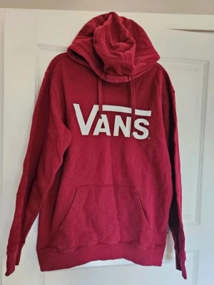 Hoodie Vans M - Grym röd hoodie från Vans – Redo för nya äventyr!  Tjena! Säljer min coola röda hoodie från Vans, perfekt för dig som gillar skön stil och ultimat komfort. Den här hoodien är din nya bästa vän för allt från soffhäng till spontana utflykter. Den är mjuk, varm och har den där klassiska Vans-looken som aldrig går ur tiden.  Jag har haft den som en favorit, men nu är det dags för den att sprida glädje hos någon annan. Den är i superbra skick och redo att ge dig massor av sköna stunder. Perfekt att s