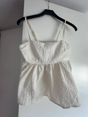 Vit topp Monki  - En eggvit topp från Monki. Toppen har tunna axelband, smock i ryggen. Säljer då den inte kommer till användning, inte använd så många gånger. 