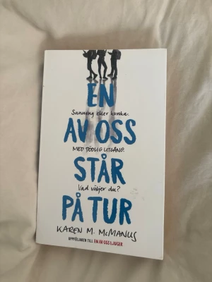 En av oss står på tur - Spännande ungdomsroman av Karen M. McManus med vitt omslag och blå text. Boken handlar om ett farligt spel på Bayview High där sanningen kan få dödliga konsekvenser. Perfekt för dig som gillar mysterier och oväntade vändningar.