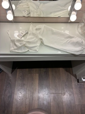 Off-white puffärmad one shoulder top (NY med lappar!) - Säljer denna drömmiga topp då den tyvärr inte kommit till användning. Helt ny med prislappen kvar! Snygg off-white färg med rynkade detaljer fram och en kaxig, voluminös puffärm på ena sidan. Perfekt skick!                                         Storlek: S                                                                            Märke:Zara