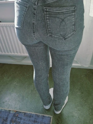 Gråa skinny jeans med hög midja - Säljer ett par gråa skinny jeans med hög midja och klassiska bakfickor. Jeansen har en tvättad look och smal passform som sitter tight hela vägen ner. Perfekta till vardags för en avslappnad men snygg stil.Ej retur.