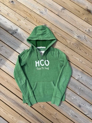 Hollister hoodie ~ Vintage  - Säljer denna Hollister hoodie i mycket bra skick och som är Vintage så därmed väldigt eftertraktad. Storlek S men passar XS. Passar perfekt för dig som är mellan 160-165! Hör av er vid frågor eller minsta fundering 🙌  Längd: 57 cm  Bred: 42,5 cm  Ärm: 63,5 cm