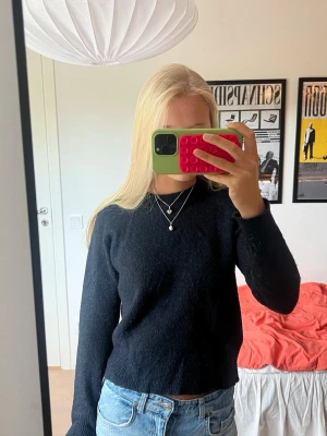 Mörkblå stickad tröja - Mörkblå stickad tröja i bl.a. ull och alpacka från Selected Femme med rund halsringning och långa ärmar. Jättemysig att ha både hemma och tillvardags! Tröjan har fått lite rosa färg på ena ärmen (se sista bilden). Materialet är ull, polyester, alpacka, nylon och elastan. Nypris 600 kr.