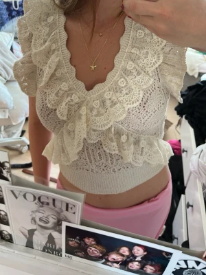 Beige spetsblus med volanger - Supersöt beige blus med spetsdetaljer och stora volanger framtill och vid ärmarna. Blusen har v-ringning och är stickad med ett jättefint mönster. Från Zara och säljs inte längre, så slå till!😉