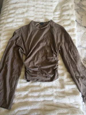 Brun långärmad topp med breda ärmar - Säljer en mjuk och skön brun långärmad topp med breda ärmar. Materialet känns lent mot huden och toppen är lätt att matcha med olika outfits🤎