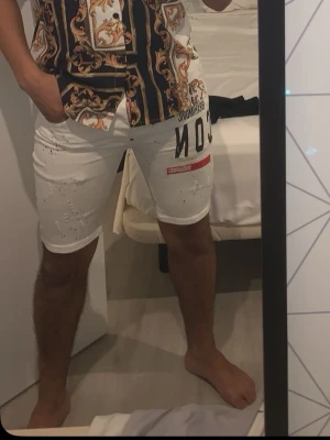 Vita ICON shorts från Dsquared2 - Säljer ett par vita jeansshorts från Dsquared2. Shortsen har coola slitningar, färgstänk. Passar sig som är mellan 65kg-75kg. Har även ett par till svarta 