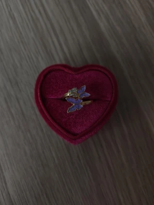 Guldfärgad ring med lila fjärilar - Fjärilar ring i storlek 18,1mm, guldfärgad.