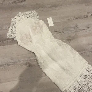 Studentklänning  - Studentklänning med fransar som går att klippa av om man så skulle önska. Helt ny med prislapp, nypriset 1300! 