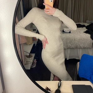 Stickad klänning - Super fin och smickrande beige stickad klänning med slits på båda sidor från nakd. Köpt för 600kr. Använd 1 gång 💖