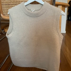 Arket Alpaca Yak Väst  - Populär väst från arket i ljusbeige. Använd 1 gång kommer i nyskick. Alpaca 32%, Yak ull 25%, Ull 22%, Polyamid 21%
