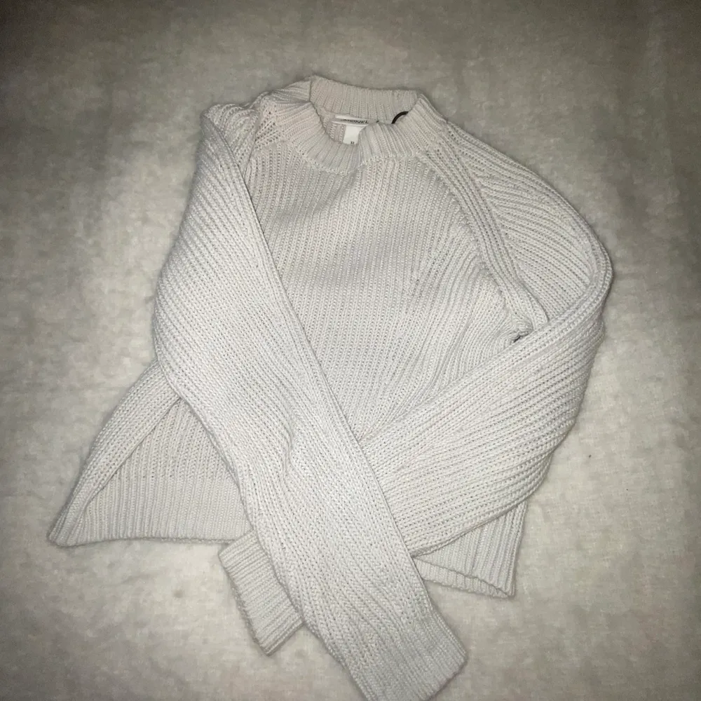 En stickad tröja som är grå/beige och tröjan passar en som brukar ha xs/s eftersom den är stretchig . Stickat.
