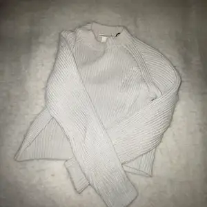 En stickad tröja som är grå/beige och tröjan passar en som brukar ha xs/s eftersom den är stretchig 