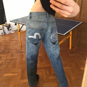 Evisu jeans  - Ett par snygga evisu jeans i rak model med slits där nere. Om ni kollar på bild tre så ser det ut som att någon har sytt på andra fickor, men det är modellen och designen på byxorna hur det ska se ut. Jag och min pappa som är kunnig har inspekterat jeansen och vi tror att det är äkta evisu, dem har olika detaljer och sömar som evisu jeans är kända för🥂🍸. Har själv sytt in dem i midjan. Men det är bekväma och bra sydda. 