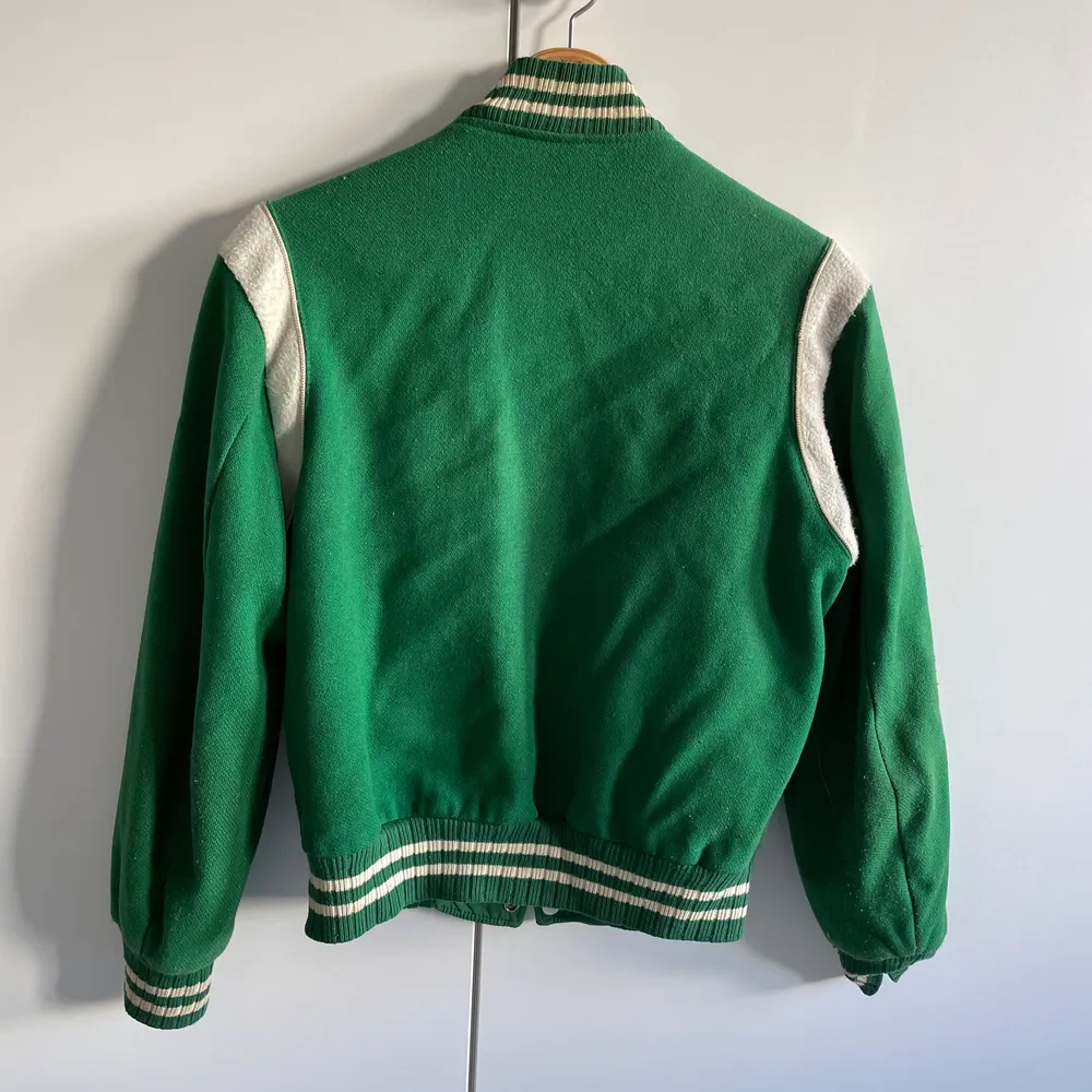 En superfin grön varsity jacka från 70 talet köpt i USA, passar en xs - s kille vilket är som en S - M tjej. Med tanke på att den är nästan 50 år gammal så finns det lite slitningar.. Jackor.