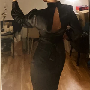 Satinklänning från NA-KD - Superfin svart satinklänning med öppning i ryggen från NA-KD i strl 32 som ALDRIG ANVÄNTS och därav har lappen kvar💙 Klänningens dragkedja kan krångla ibland men det brukar lösa sig:) Säljer då den inte kommit till användning⚡️ Pris exklusive frakt! Kontakta mig vid frågor😚