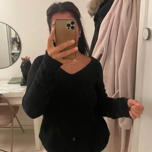 Stickad tröja Nelly  - Stickad svart tröja med öppen rygg. Knappt använd st 36. 