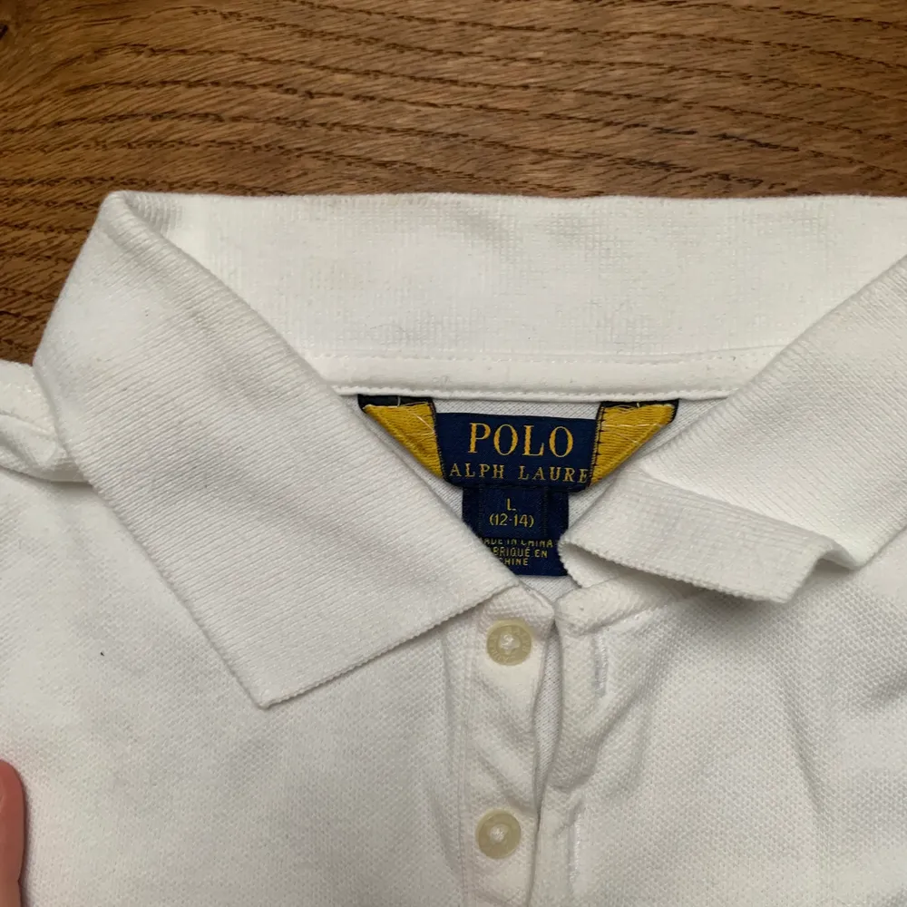 Knappt andvänd polo i storlek 12-14 år . T-shirts.