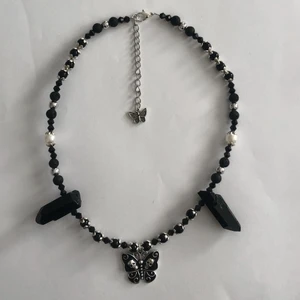 Fjäril halsband - Otroligt fint halsband med flera olika typer av pärlor, bl.a lava pärlor, glas pärlor, rodium pläterade silver pärlor och akrylpärlor. Tråden är rostfri! De två svarta kristallerna är ej äkta! Halsbanden är ungefär 45cm och förlängningskedjan är ca 7cm. 🖤