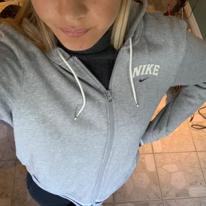 Nike zip hoodie - Så mjuk och skön zip hoodie från nike!! Något oversize passform på mig som är en storlek 36-38 och 175cm. Så fina detaljer med streck på muddarna!! Som ny och inget tecken på användning finns💌 Skriv för fler bilder eller frågor!