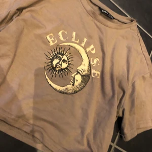 Fin t-shirt - En magtröja, inte jätte kort dock. Fin brun/beige färg. Men ett tryck på! Passar xs-s