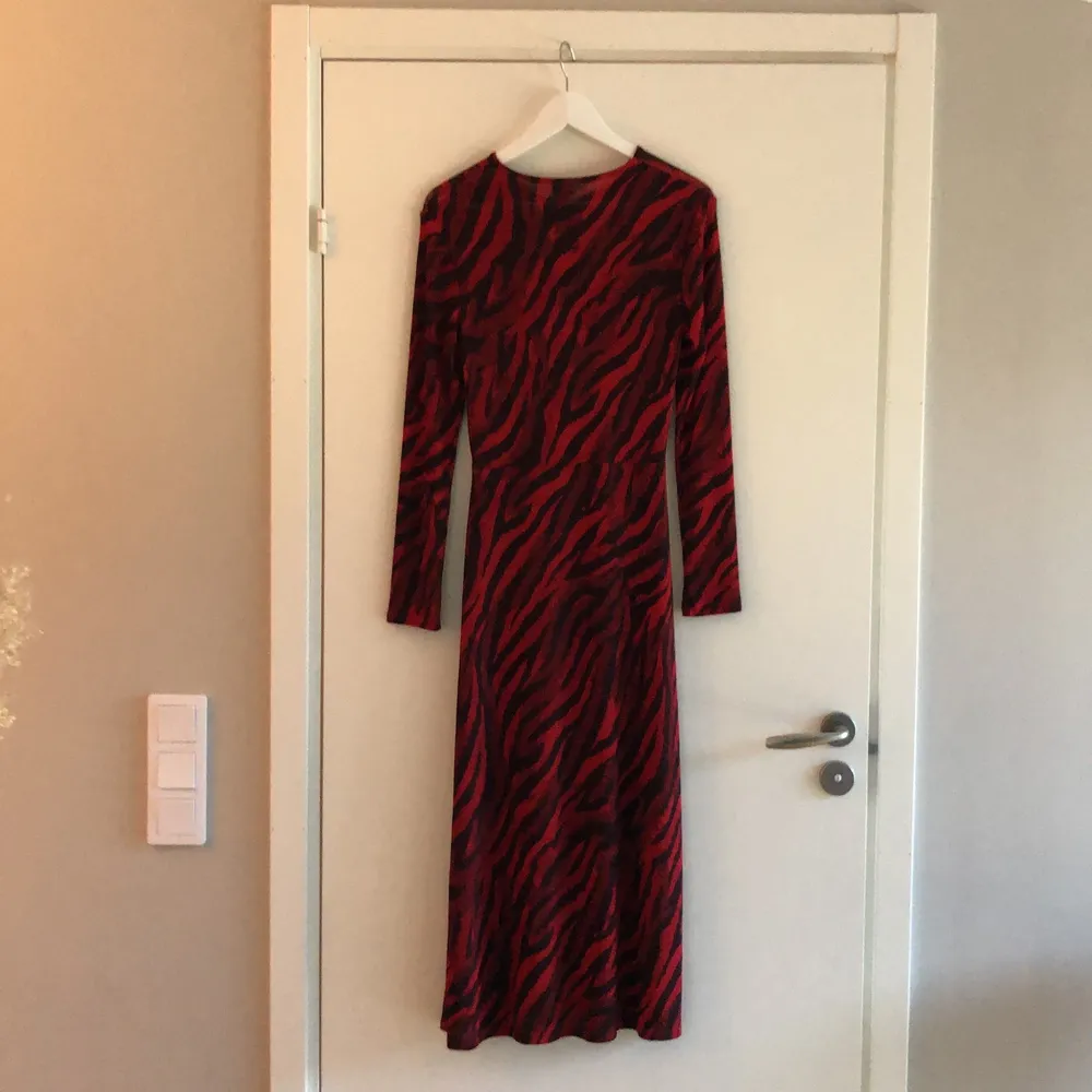 Röd och svart klänning i zebramönster! Tight modell som går ut nertill. Använd 1 gång. . Klänningar.