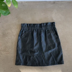 Svart kjol  - Svart kjol i läderimitation! Skulle säga att den är storlek 38 men passar även 36:or då den har resår baktill:) Kjolen har även två fickor fram vilket är GULD värt! 