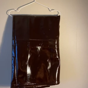 En brun ”skinn” kjol  - En skinn kjol ifrån asos som aldrig är använd. Kjolen är i storlek 54. Och går ner till precis efter knät. Kjolen har en lite slit baktill 