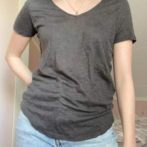 En grå/svart basic t-shirt från h&m med v-ringad hals, storlek xs med s kan även ha, köparen står även för frakt kostnaden 