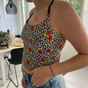 Cool backless topp  - Topp i leopard mönster med rosor på som är köpt på second hand 🥰 den är backless, man knyter den i ryggen. Väldigt bra skick och har bara haft på mig ett fåtal gånger!