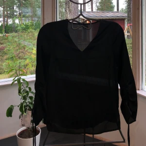 V-ringad blus med knytning på armarna  - Blus med knytning på armarna 