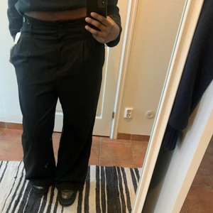 Svarta kostymbyxor  - Säljer svarta wide-leg kostymbyxor från KappAhl. Byxorna har de klassiska vita ränder i brukar finnas på kostymbyxor och de är i storlek 40. För mer info eller bilder är det bara att skriva :)