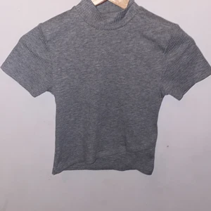 Tröja - Det är en grå tröja men halsen är det lite med långare och den finns en streck på tröjan