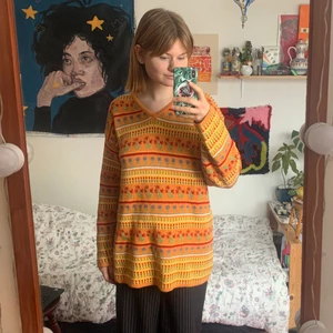 Blommig stickad tröja - En otroligt fin stickad tröja i retro-modell. Säljer pga att den inte kommer till användning. En tröja som piggar upp vilken outfit som helst. Ganska lång i modellen, så går att styla på många sätt. Väldigt fint skick, inte alls nopprig eller urtvättad! Klara starka färger!